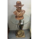 Cowboy themed glass top side table with replica gun holster, bullets and hat, together with a bust