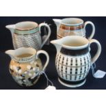 Three early 19th Century mocha ware jugs of baluster form with checkered, striped and other