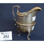 Silver helmet shaped cream jug with loop handle on C scroll feet. Birmingham hallmarks, 4 troy ozs