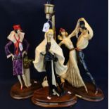 A Santini, three Art Deco style figurines/figure groups on wooden plinths, one standard lamp. (3) (