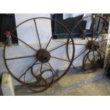 Pair of large weathered cast iron wagon wheels, together with a pair of smaller wheels. (4) (B.P.