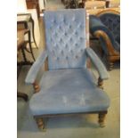 Late Victorian mahogany framed upholstered button back open armchair on turned supports and casters.