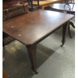 Edwardian mahogany extending dining table on square tapering legs and casters, no winder or