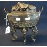 Oriental bronze censer of oval two handled boat shaped form, having pierced foliate cover