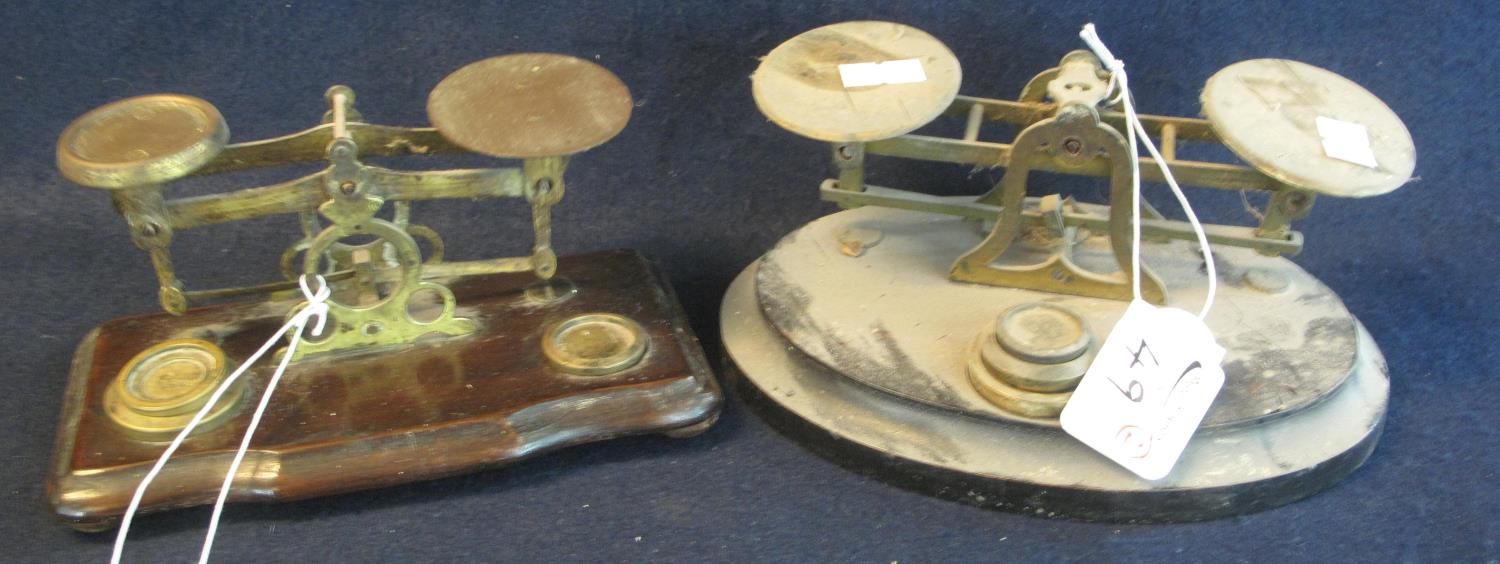 Two sets of brass letter scales, on wooden bases with brass weights. (2) (B.P. 21% + VAT)