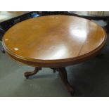 Victorian mahogany circular tilt top centre table on a triform scroll decorated base and casters. (