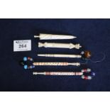 Three bone motto lace bobbins with beads, a bone needle case and an ivory needle case. (5) (B.P. 21%