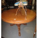 Victorian mahogany circular tilt top centre table on a triform scroll decorated base and casters. (