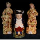 19th Century painted toby jug, together with two ceramic figurines. (3) (B.P. 21% + VAT)