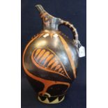 An unusual Art pottery single handled jug of baluster form on a brown and orange ground in the