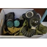 Two Second World War type gas masks in canvas cases, another in metal cylinder. (3) (B.P. 21% + VAT)