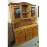 Modern pine two stage dresser having two glazed doors above fitted drawers on a platform base. (B.P.
