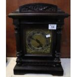 Early 20th century German carved architectural three train mantel clock having brass face and