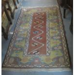 Turkish Melas rug on a salmon ground with stylised petals and meandering border design, together