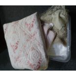 Box of vintage textiles to include; a vintage cotton quilt, floral to one side and pale pink to