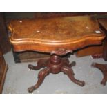 Victorian walnut fold over card table, the blue leather baize above a carved quatreform base on cups