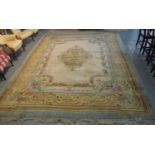 Large cream ground rug with blue banding and rose and other floral and foliate decoration. (B.P. 21%
