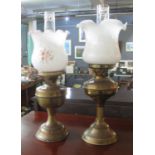Two similar early 20th century double oil burner lamps, one with floral shade on brass bases. (2) (
