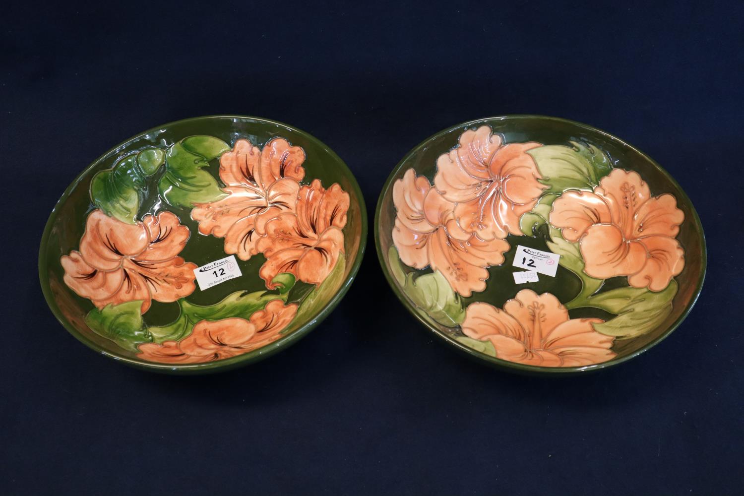 Pair of Moorcroft art pottery tube lined pedestal bowls on a green ground with pink flower heads and