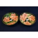 Pair of Moorcroft art pottery tube lined pedestal bowls on a green ground with pink flower heads and