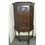 Early 20th century oak hall cupboard having moulded cornice above a carved door with fitted shelves