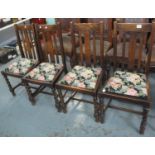 A set of four early 20th Century slat back dining chairs with tapestry drop in seats, standing on