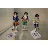 Collection of three porcelain figures: two as street vendors, the third after a Georgian ice skater,