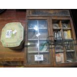 A vintage shop miniature cabinet for the sale of pen knibs - indistinctly marked, with a tin of