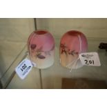 A pair of small glass lampshades on a pink and cream ground with floral decoration. (B.P. 21% + VAT)
