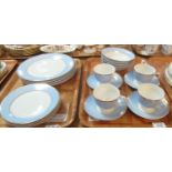 Two trays of Royal Doulton tea and dinner ware items on a white ground with blue and gilded banding,