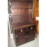 Small early 20th century trained oak dresser with boarded two shelf back, over two drawers and two