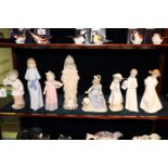 Eight Nao Spanish porcelain figurines of young girls and boys, one playing a violin, the other