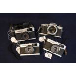 Olympus OM20 35mm SLR camera body together with three Olympus trip 35 viewfinder cameras, one with