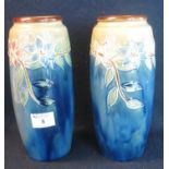 Pair of early 20th Century Royal Doulton stoneware vases decorated on a blue ground with tube