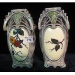 Pair of continental Art Nouveau design pottery vases decorated with reserved panels of flowers and