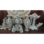 Dresden porcelain figure and cherub mounted foliate decorated clock garniture, the clock with two