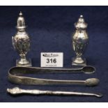 Pair of silver pedestal pepperettes, pair of silver sugar nips, and a silver-handled button hook.