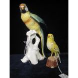 Continental porcelain study of a long tailed parrot on a tree stump, together with a Goebel figure
