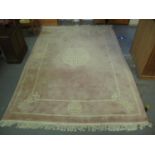 Large Chinese wash ground rug with Chinese symbols on a pink ground. 380 x 248cm approx. (B.P. 21% +