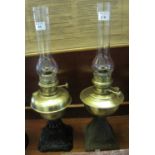 Two similar brass oil lamps with cast metal bases and clear chimneys. (2) (B.P. 21% + VAT)