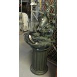 Modern garden water fountain with light shade, decorated with putti riding a dolphin, on