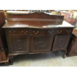 Edwardian mahogany serpentine design carved sideboard on cabriole legs and ball and claw feet. (B.P.