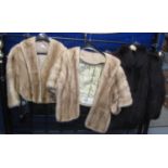 A blonde mink fur short jacket and cape and a black fox fur jacket. The cape has a 'Emba the