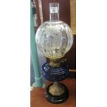 Early 20th Century brass double burner oil lamp with blue glass reservoir on metal pedestal with