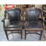 Pair of early 20th Century oak open arm office chairs with leather padded backs and seats on