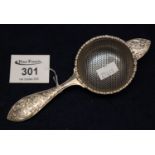 Silver c scroll and foliate decorated tea strainer with Birmingham hallmarks and makers initials D.H