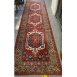 Modern Middle Eastern design runner on a red ground with geometric and foliate decoration. 345 x
