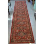 Kashqai modern wool pile master craft runner with geometric decoration on red ground. 67 x 275 cm