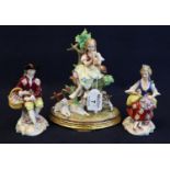 A pair of continental probably German porcelain figurines of a young lady seated with flowers and