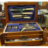 Edwardian oak canteen of cutlery with hinged lid and pull-out drawers, the interior revealing